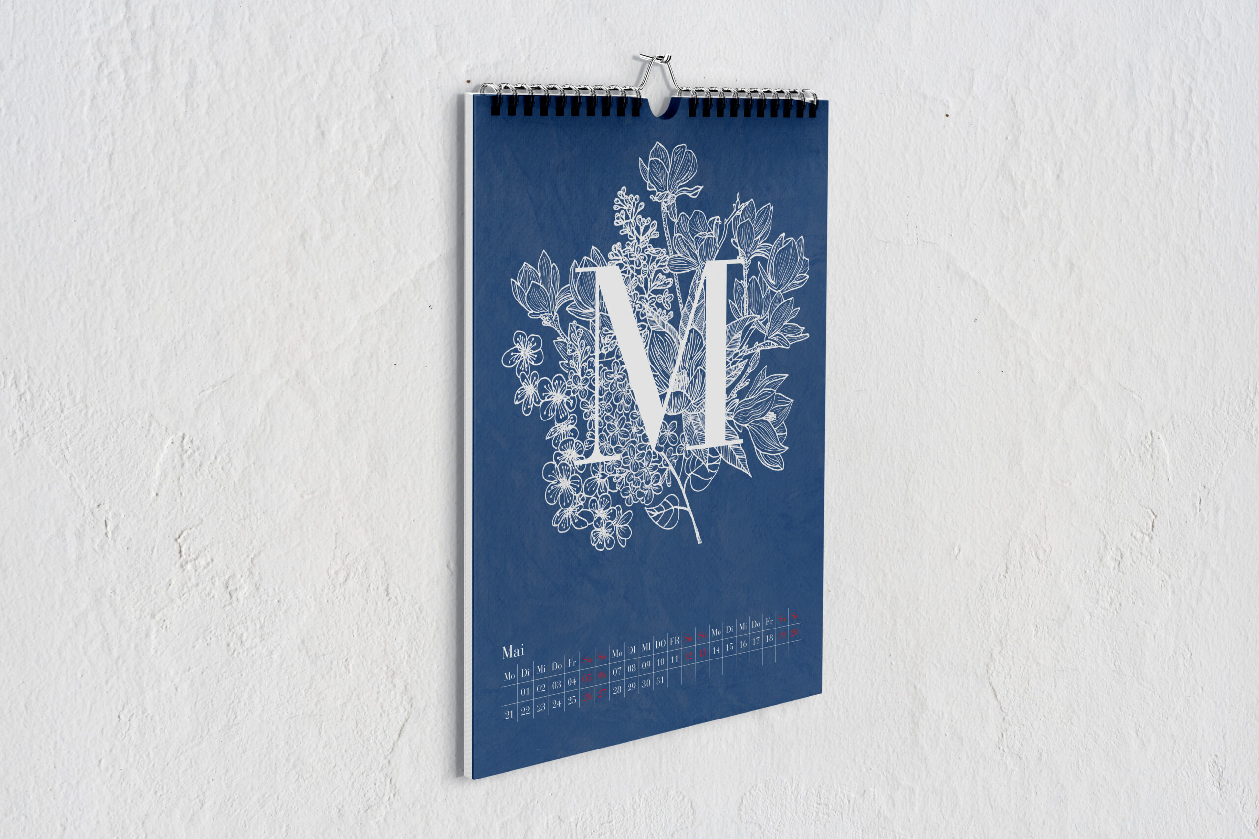 Kalenderblatt für Mai, mit einem großen weißen M vor Zeichnungen von Blumen in weiß vor blauem Hintergrund.